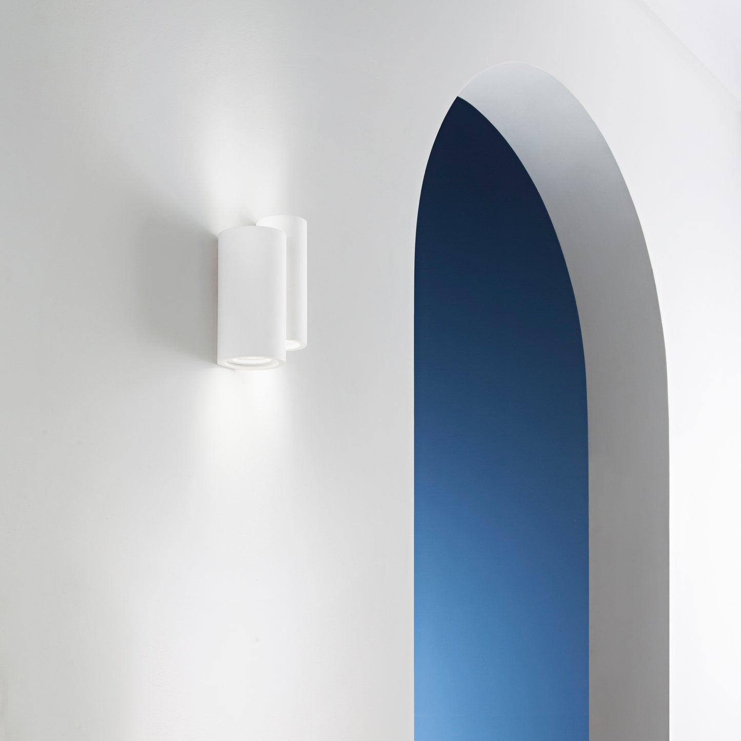 Applique BANJIE doppia in gesso bianco verniciabile con luce biemissione.