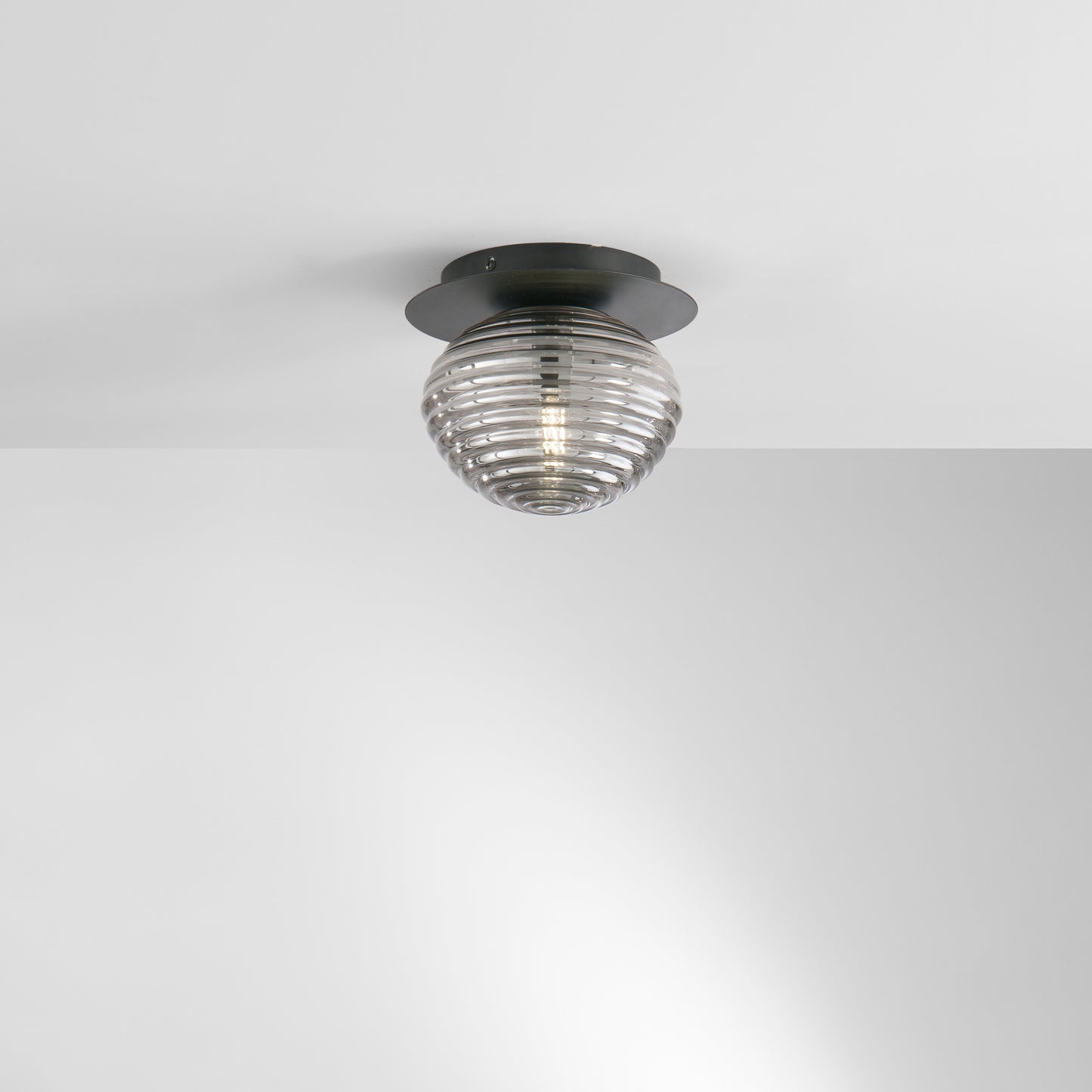 Plafoniera RIPPLE in metallo nero con diffusore in vetro fumè Ø 20cm.